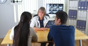 Nurse reviewing ultrasound results with pregnant couple.